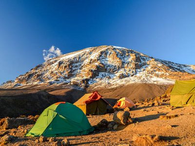 kili route Stunning evening view of Kibo with Uhuru Peak (5895m amsl, highest mountain in Africa) at Mount Kilimanjaro,Kilimanjaro National Park,seen from Karanga Camp at 3995m amsl. Tents in the foreground.